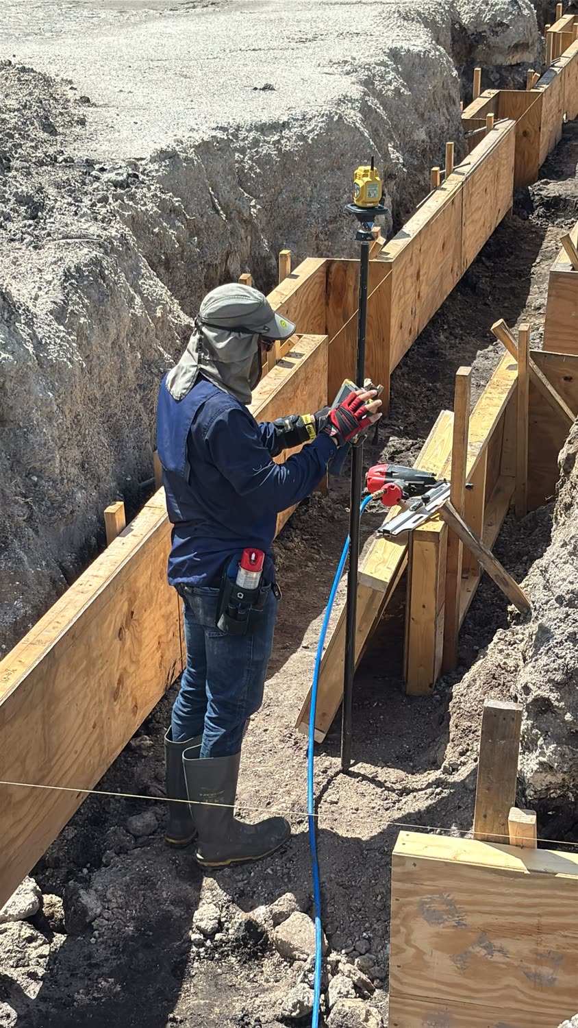 Worker setting formwork on a foundation pour