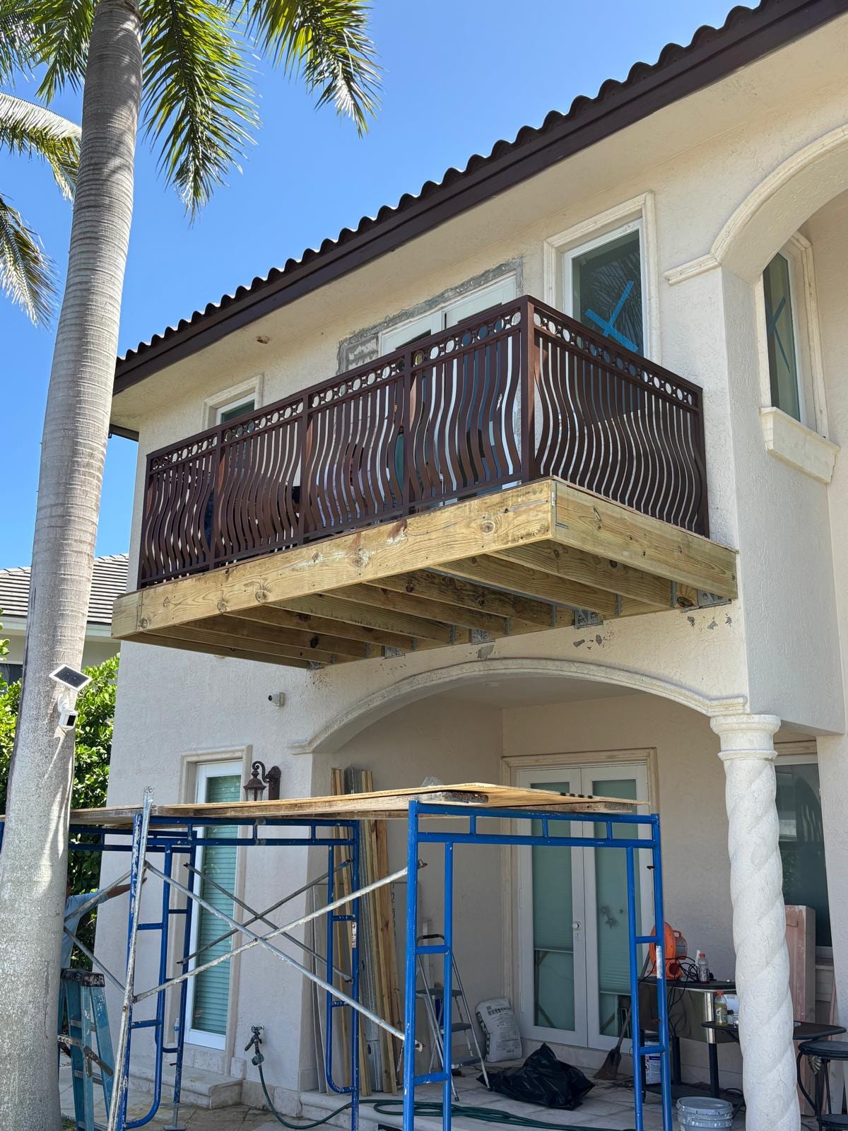 Close view of the new balcony's custom decorative aluminum railing over the wood deck platform