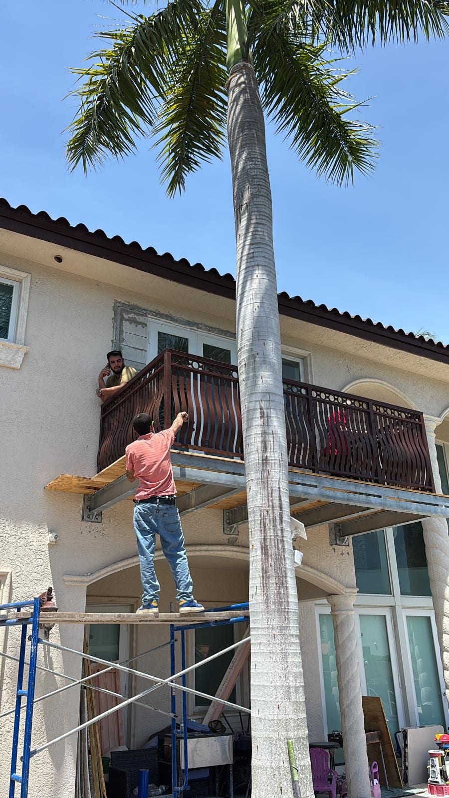 MTC crew installing the decorative balcony railing from scaffolding at the North Miami Beach home