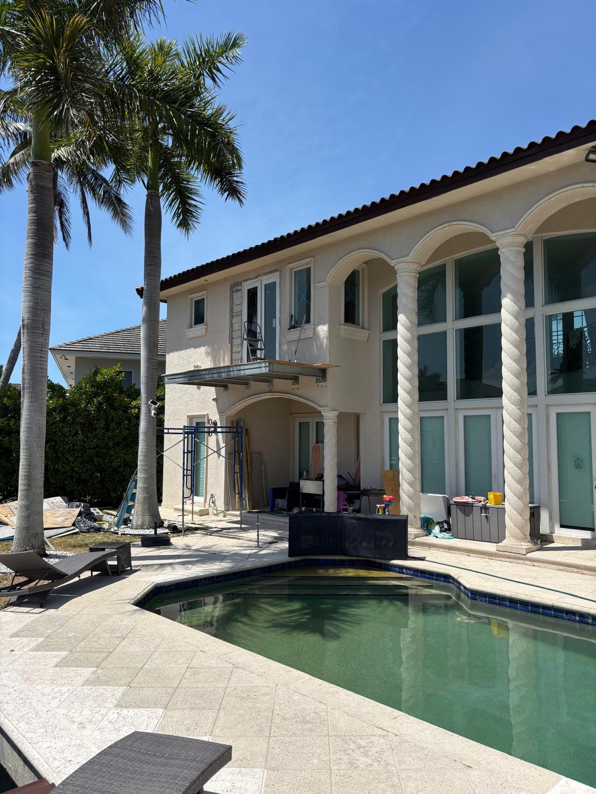 Rear elevation of the Bass Residence, a North Miami Beach waterfront home, with its new second-floor balcony above the pool