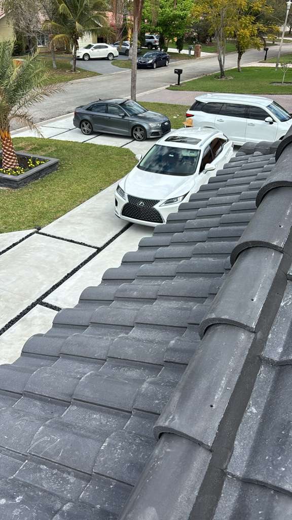 Newly installed gray tile roof on a premium South Florida residence with luxury vehicles in the driveway